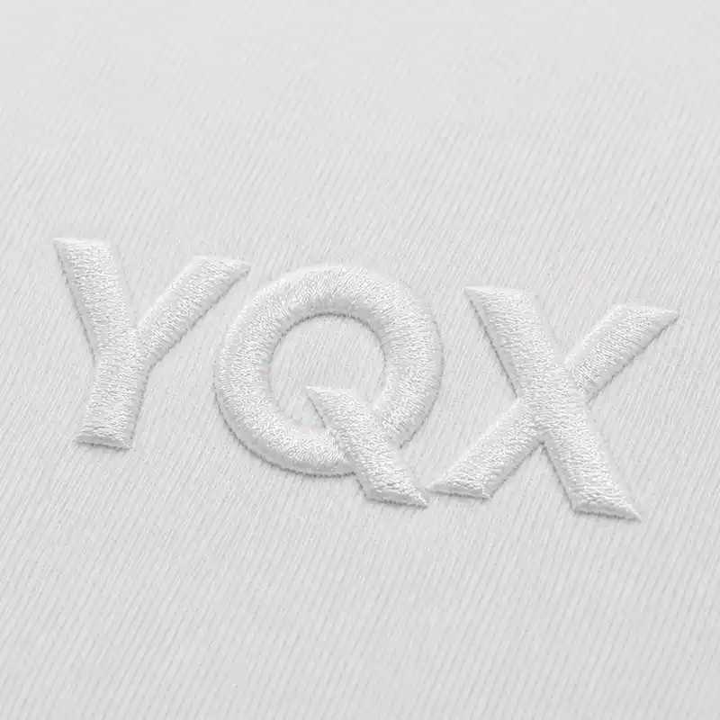 White 3D puff embroidery sample showing raised lettering on fabric for custom embroidered patches and apparel decoration.