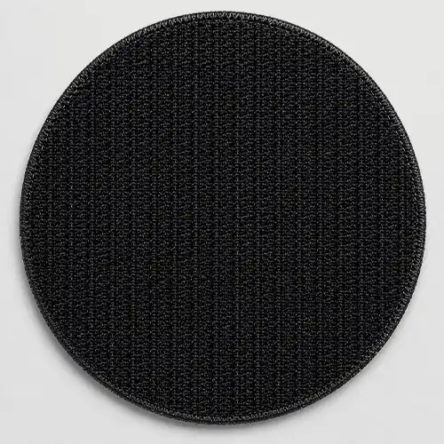 Back view of a custom round embroidered patch with black hook backing for secure removable attachment.