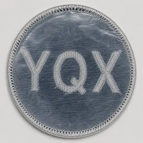 Back view of a custom round embroidered patch with a thin plastic backing for added shape and stability.