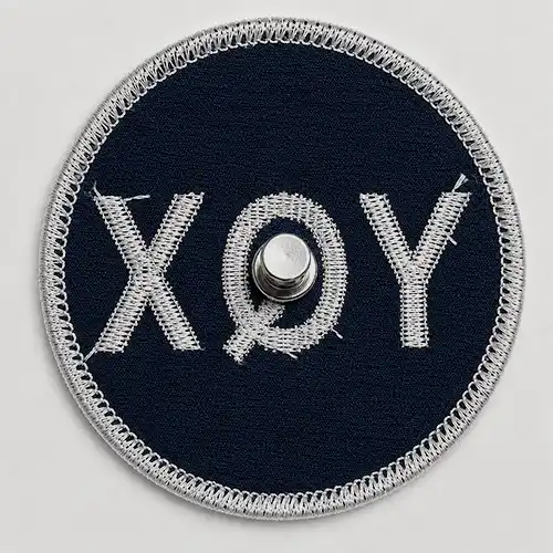 Back view of a custom round embroidered patch with a metal wearable magnet attachment.