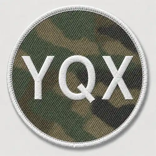 Front view of a round custom embroidered patch with a camouflage fabric base, white lettering, and a white merrowed border.