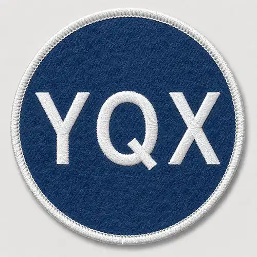 Front view of a round custom embroidered patch with a blue felt base, white lettering, and a white merrowed border.
