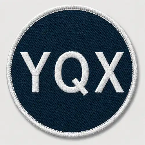 Front view of a round custom embroidered patch with a navy polyester blend twill base, white lettering, and a white merrowed border.
