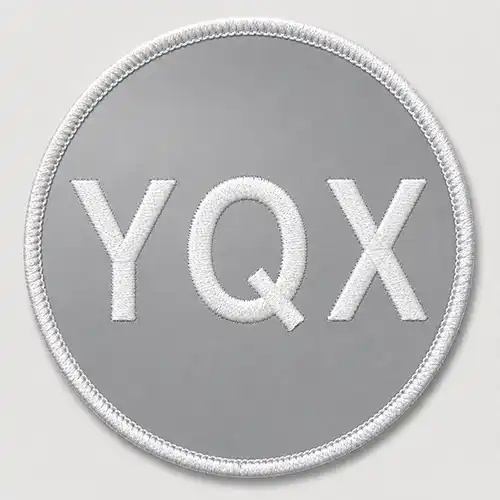 Front view of a round custom embroidered patch with a reflective material base, white lettering, and a white merrowed border.