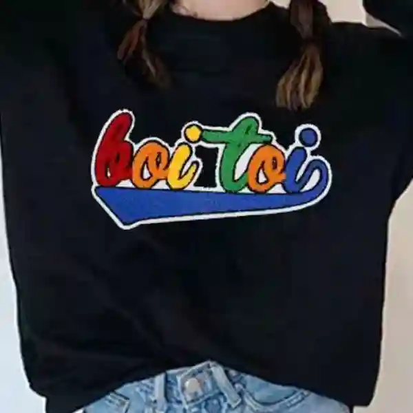 Custom multicolor chenille script patch applied to the front of a black sweatshirt for fashion apparel decoration.