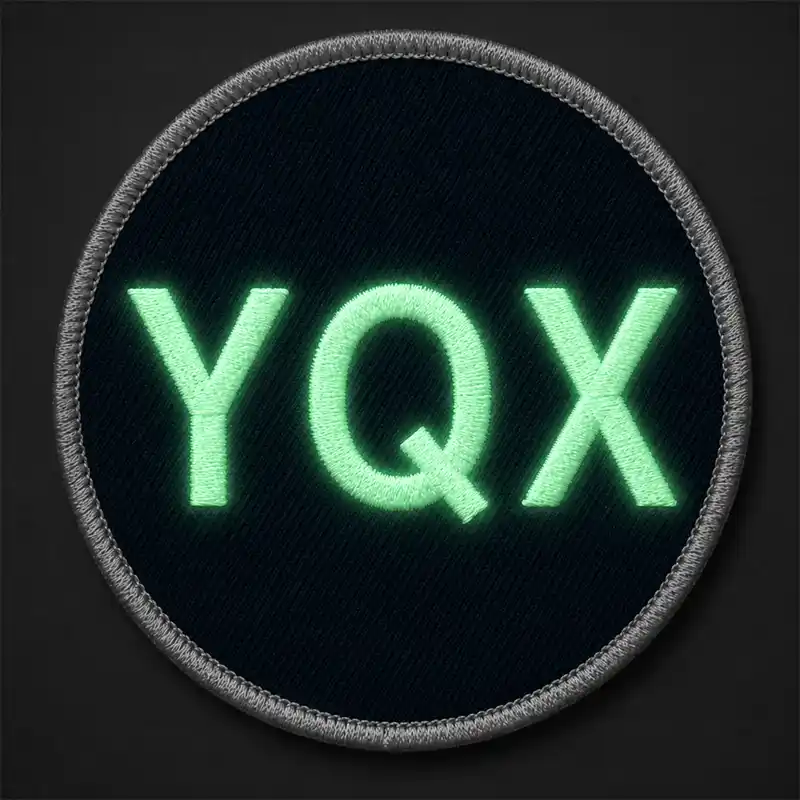 Glow-in-the-dark embroidered patch with luminous YQX lettering on a round custom patch for night visibility.
