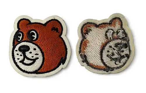 Front and back view of an embroidered patch with plastic backing for improved shape stability and a cleaner structured finish.
