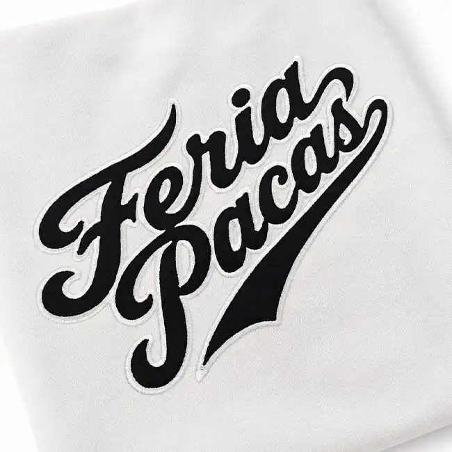 Black script logo appliqué with white embroidered edging stitched onto a white fashion garment panel.