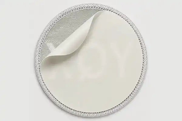 Close-up of a custom embroidered patch with self-adhesive backing, showing the peel-off adhesive layer for temporary attachment, display use, and short-term applications.