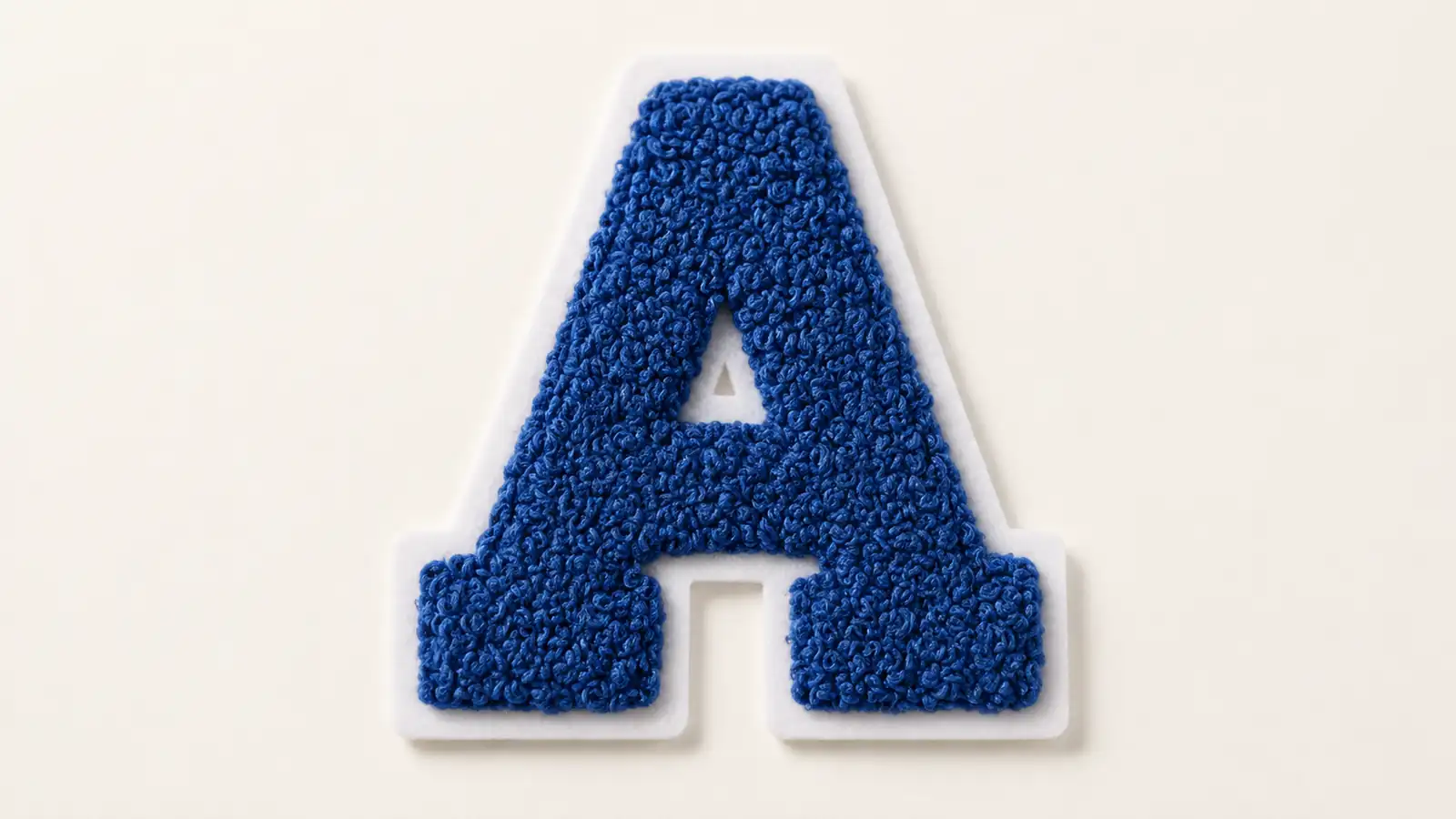 | Blue chenille letter A with a white felt border on a neutral background.
